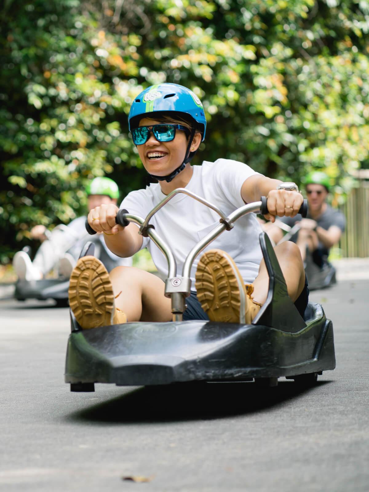 A customer smiles widely as she rides round a corner on the Luge tracks.