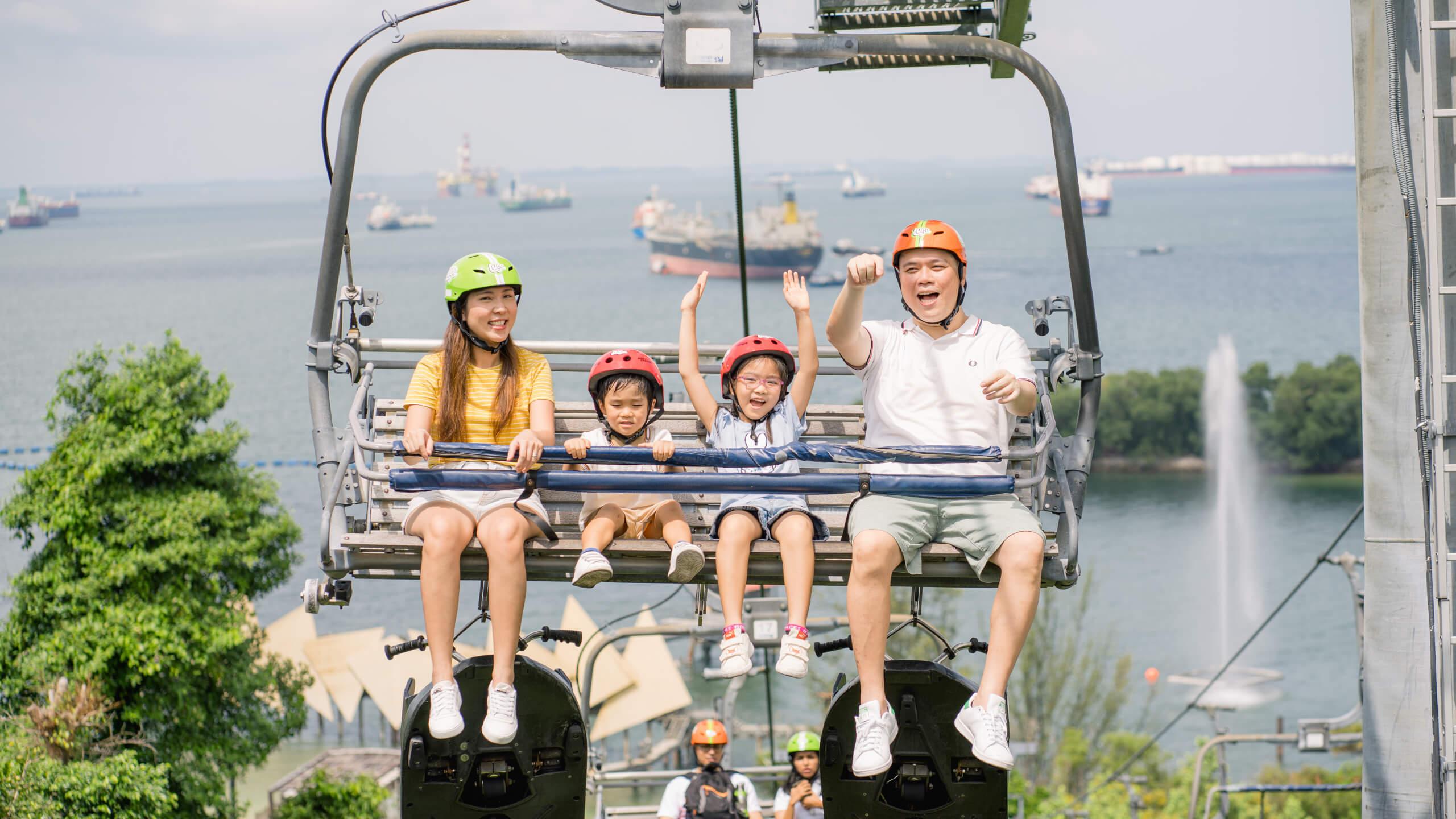 A family with two small kids rides the Skyride chairlift together.