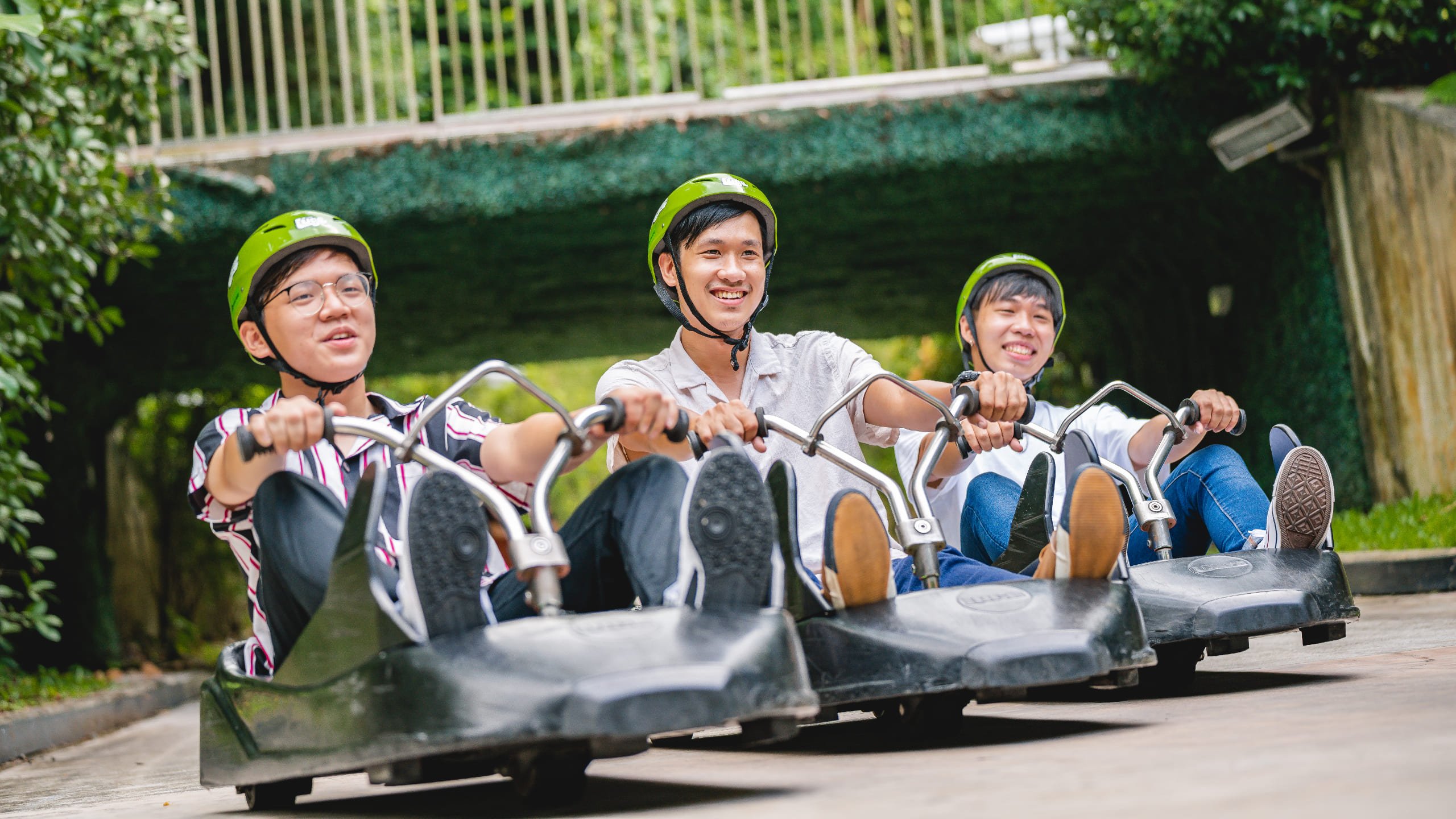 Three friends ride next to each other on the Luge at Singapore.