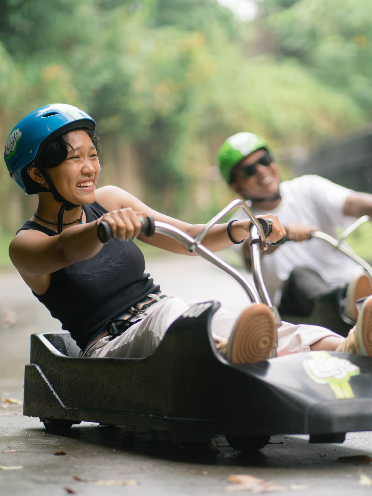 A woman laughs as she races down the Luge tracks.