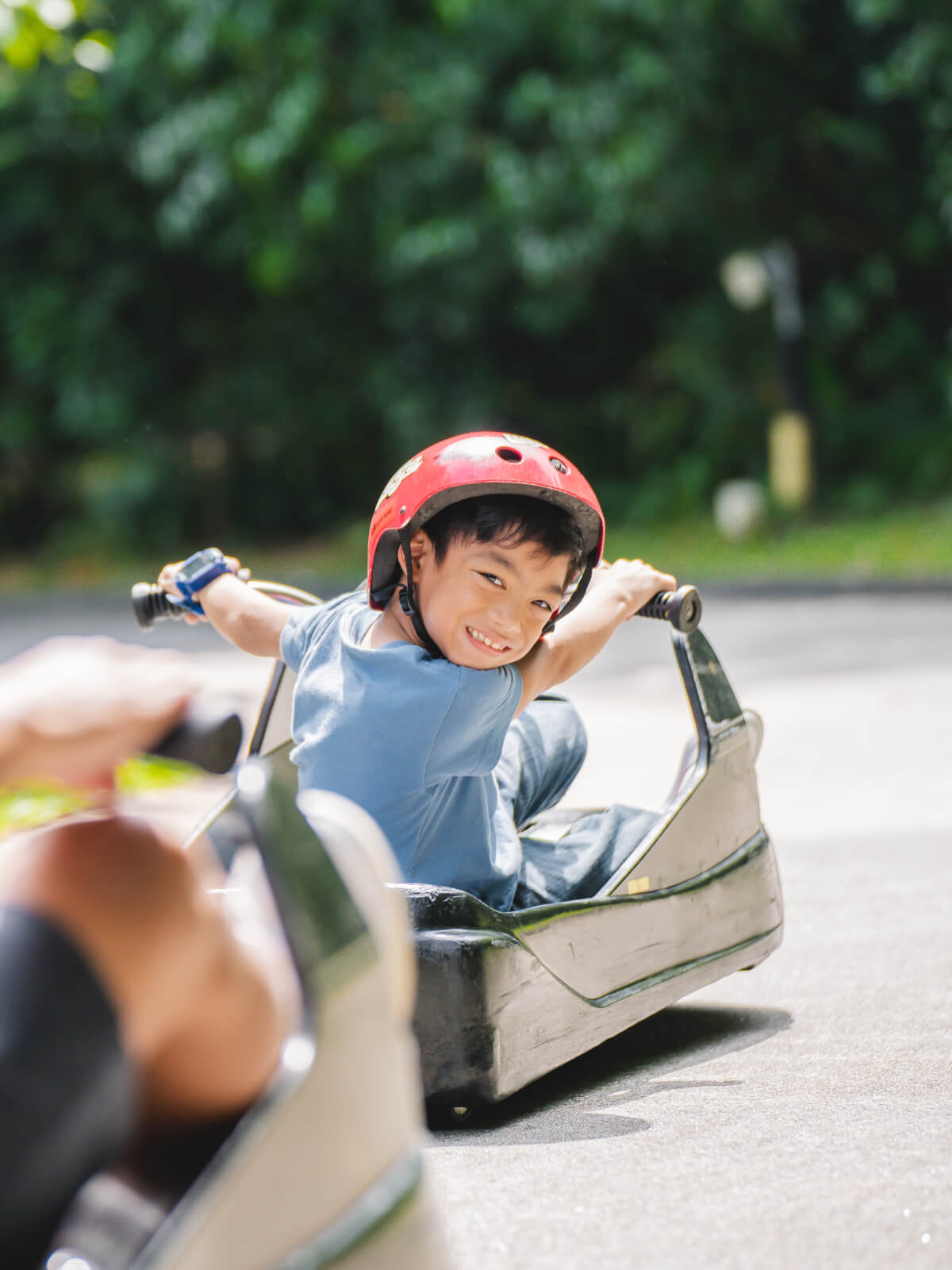 A small child turns around and grins as he rides the tracks.