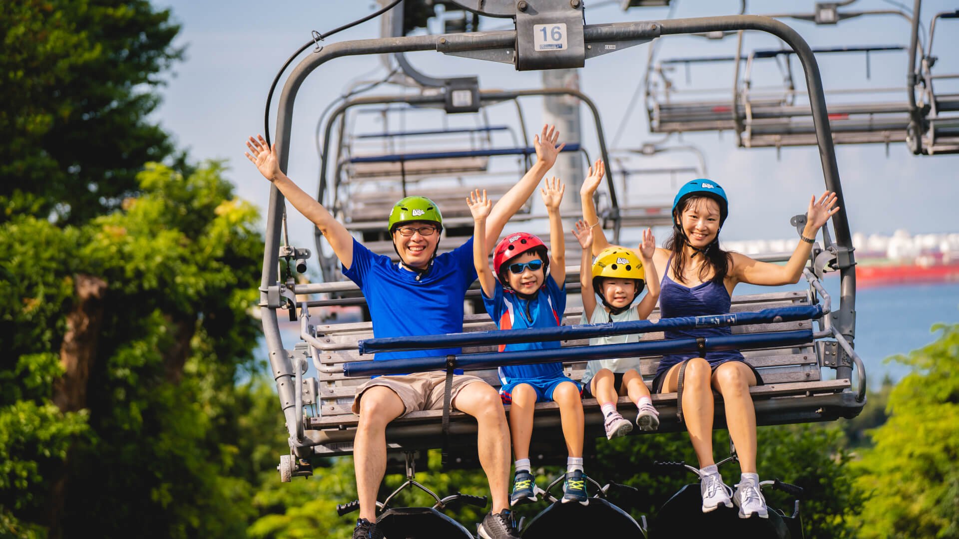 A family with two small kids rides the Skyride chairlift together.