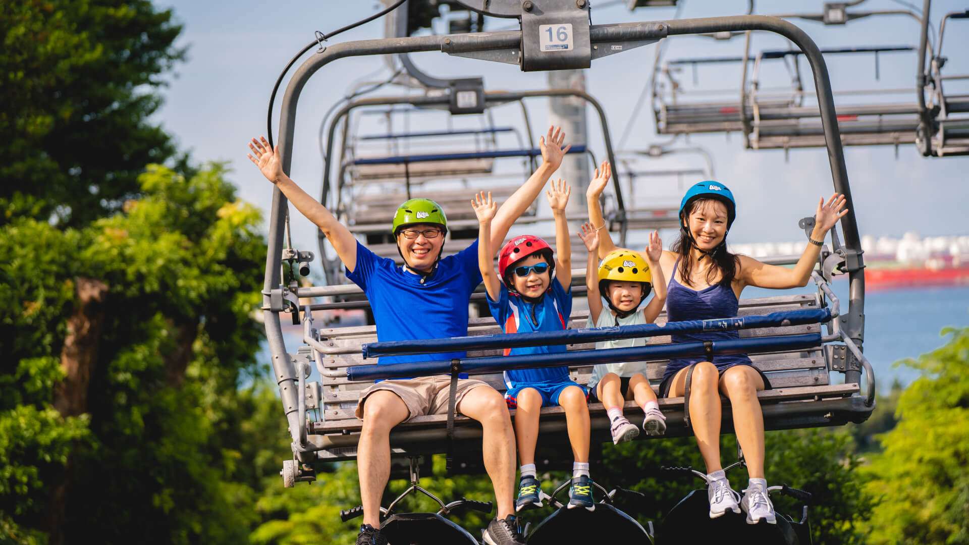 A family with two small kids rides the Skyride chairlift together.