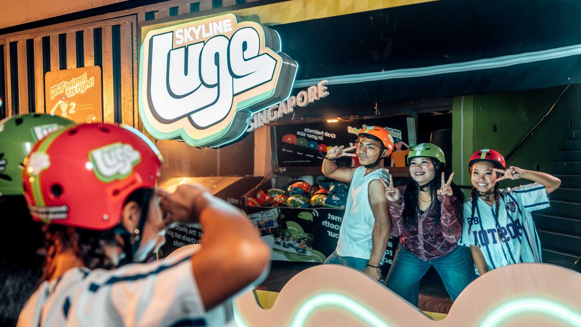 A group of youths in Y2K era fashion posing in front of a mirror at Skyline Luge Singapore