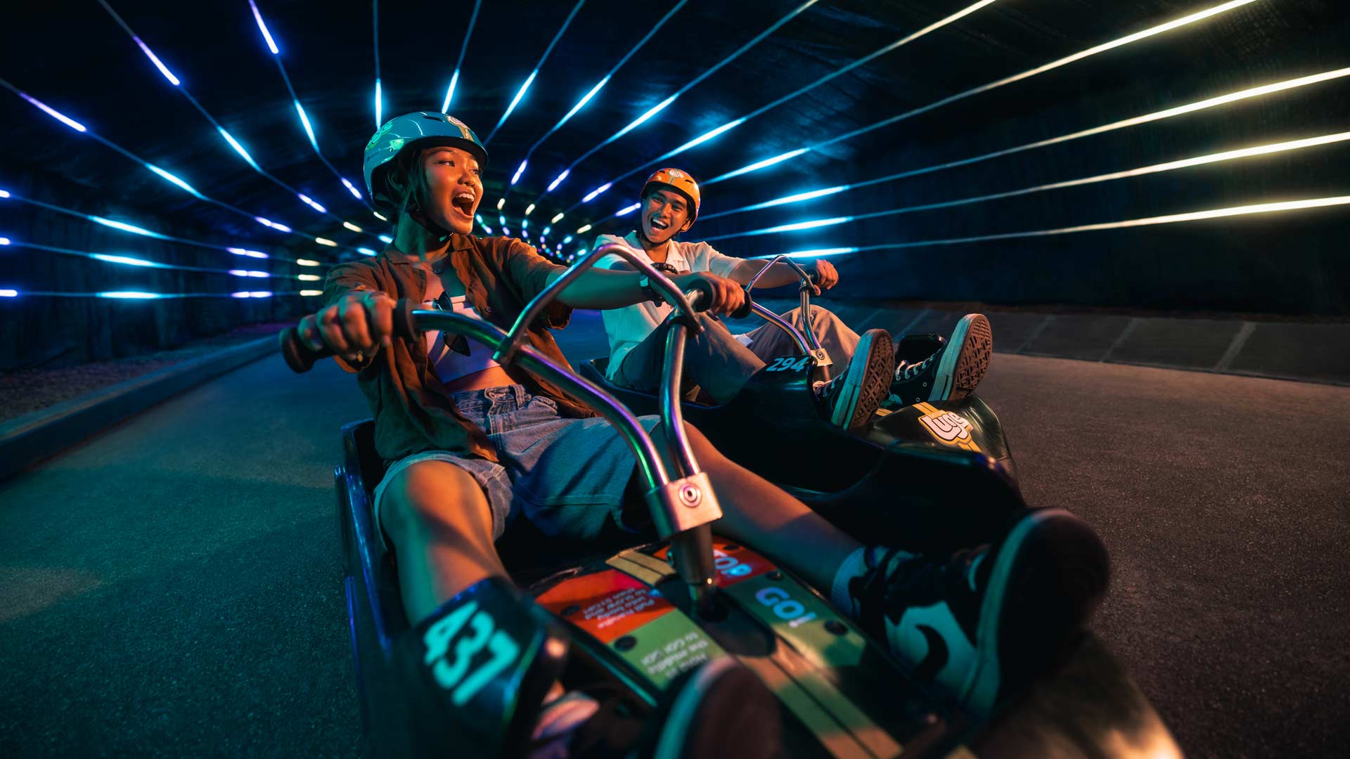 Skyline Luge Singapore a couple riding the Luge carts through the Tunnel feature during Night Luge : Ride the Beat