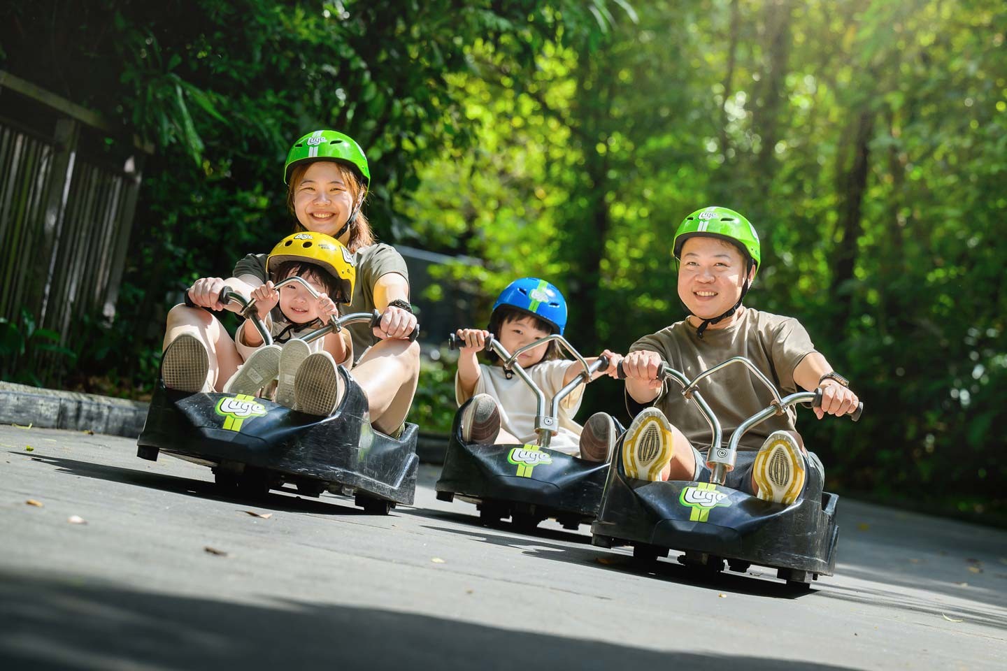 Skyline Luge Singapore - a family of four on Luge carts with one child riding tandem