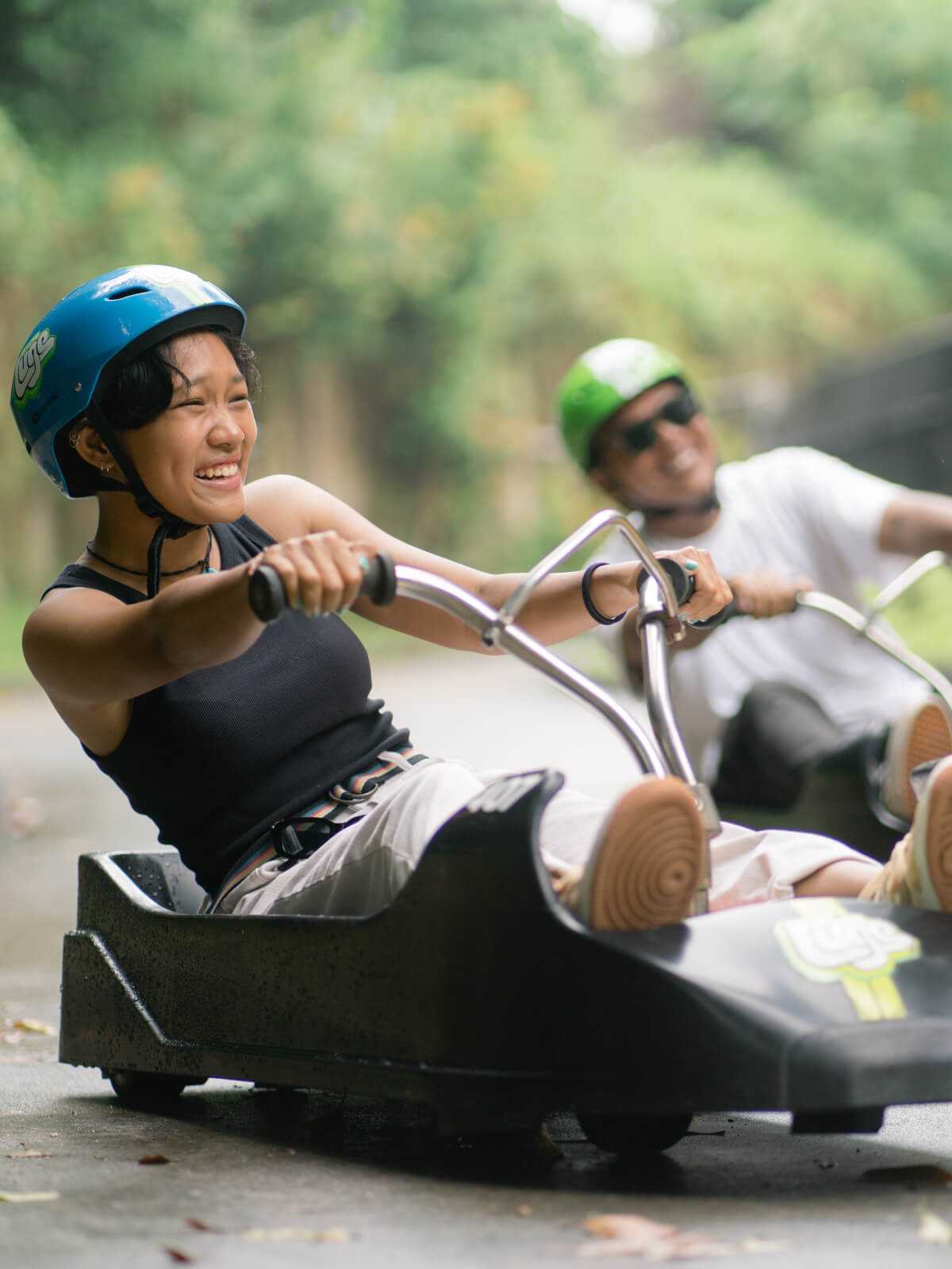 A woman laughs as she races down the Luge tracks.