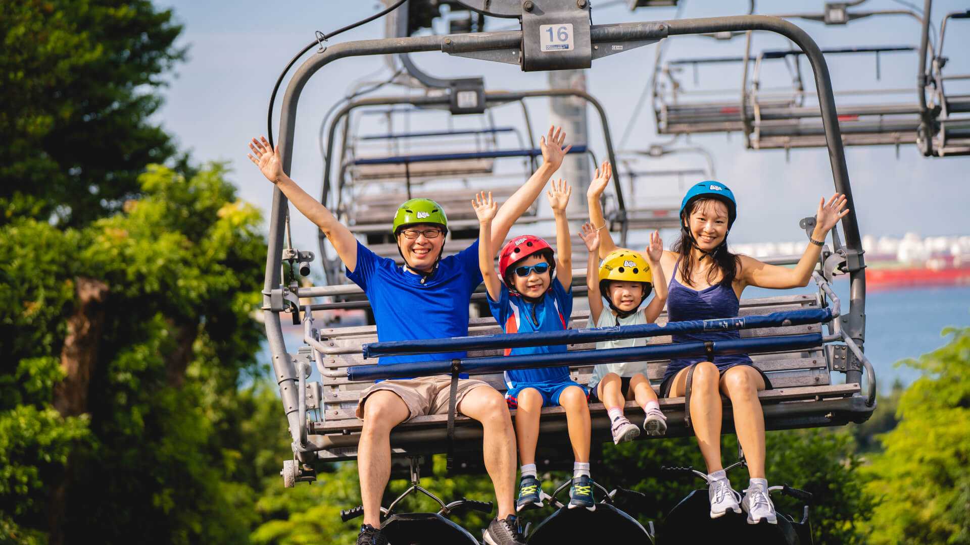 A family with two small kids rides the Skyride chairlift together.