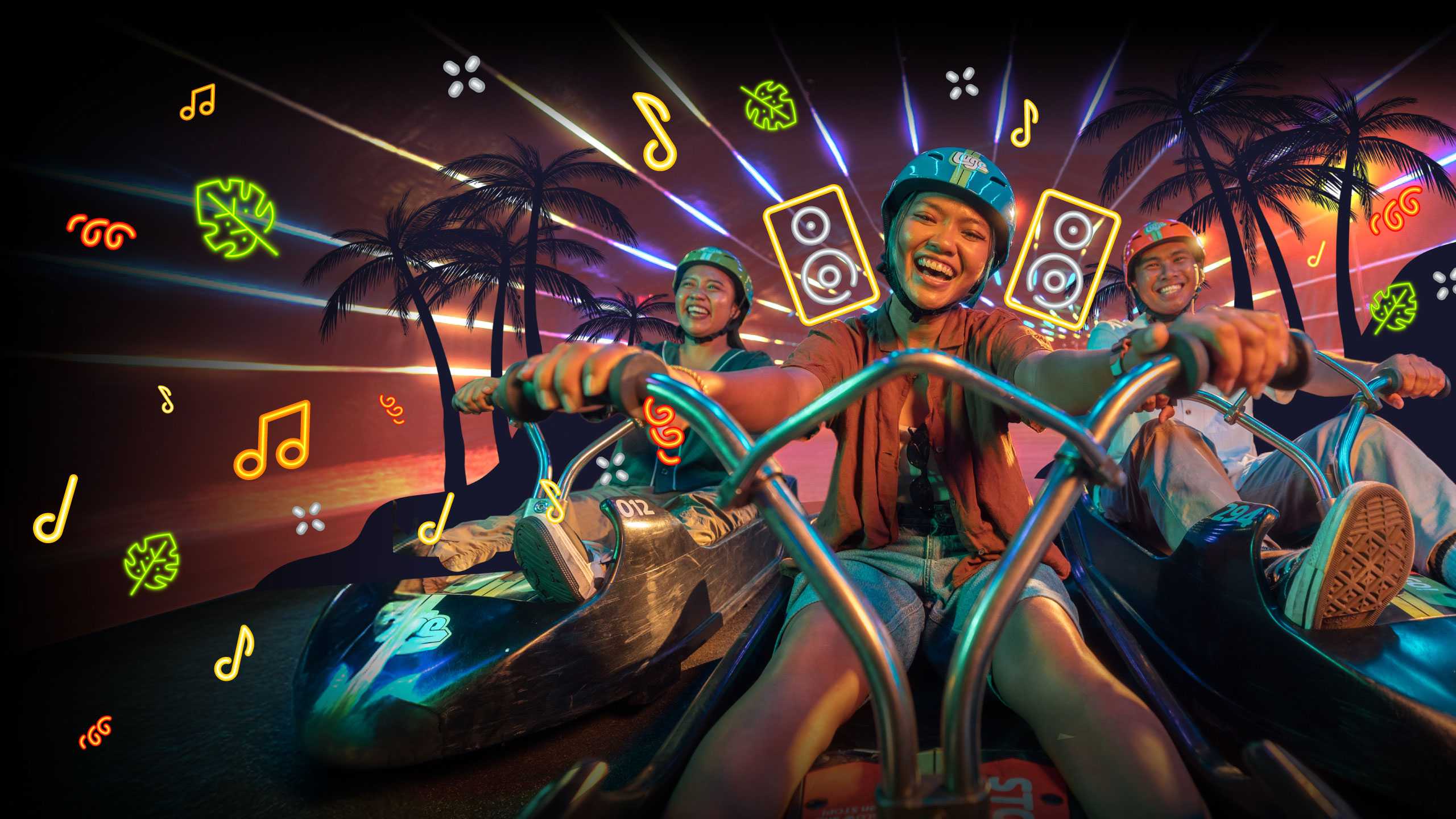 A group of people enjoying night luge with neon sign shapes of music and speakers in the background