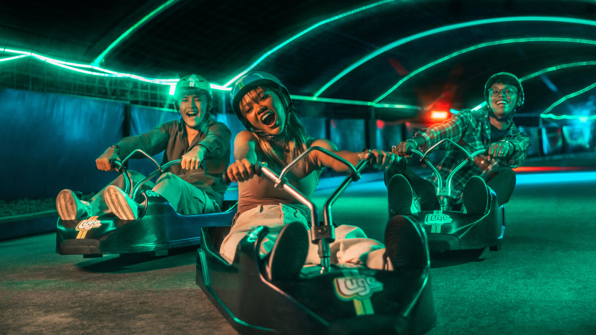 A group of people enjoy the Night Luge together.